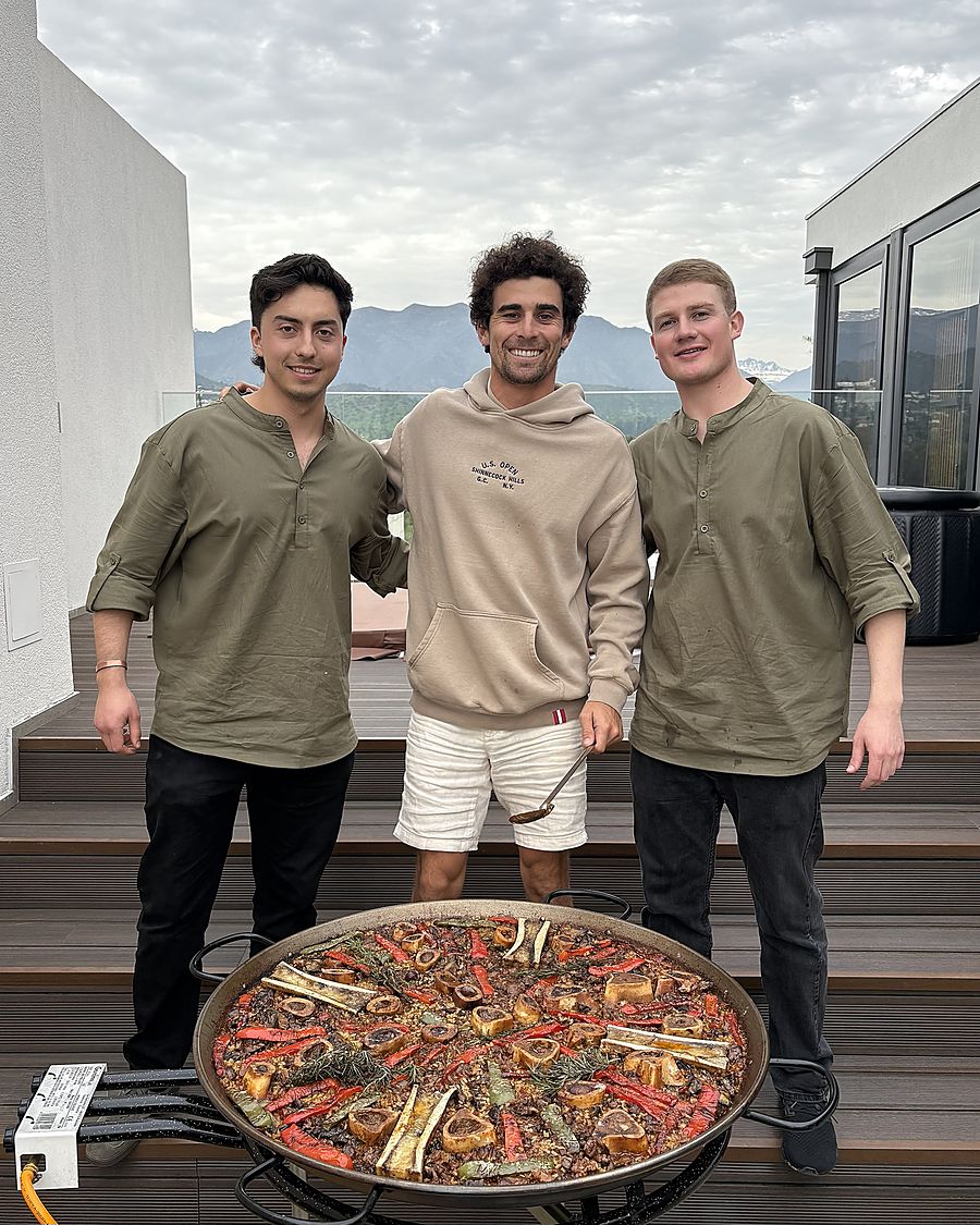 Maurice y Cristián junto a una paella de ossobuco, con la cordillera de fondo